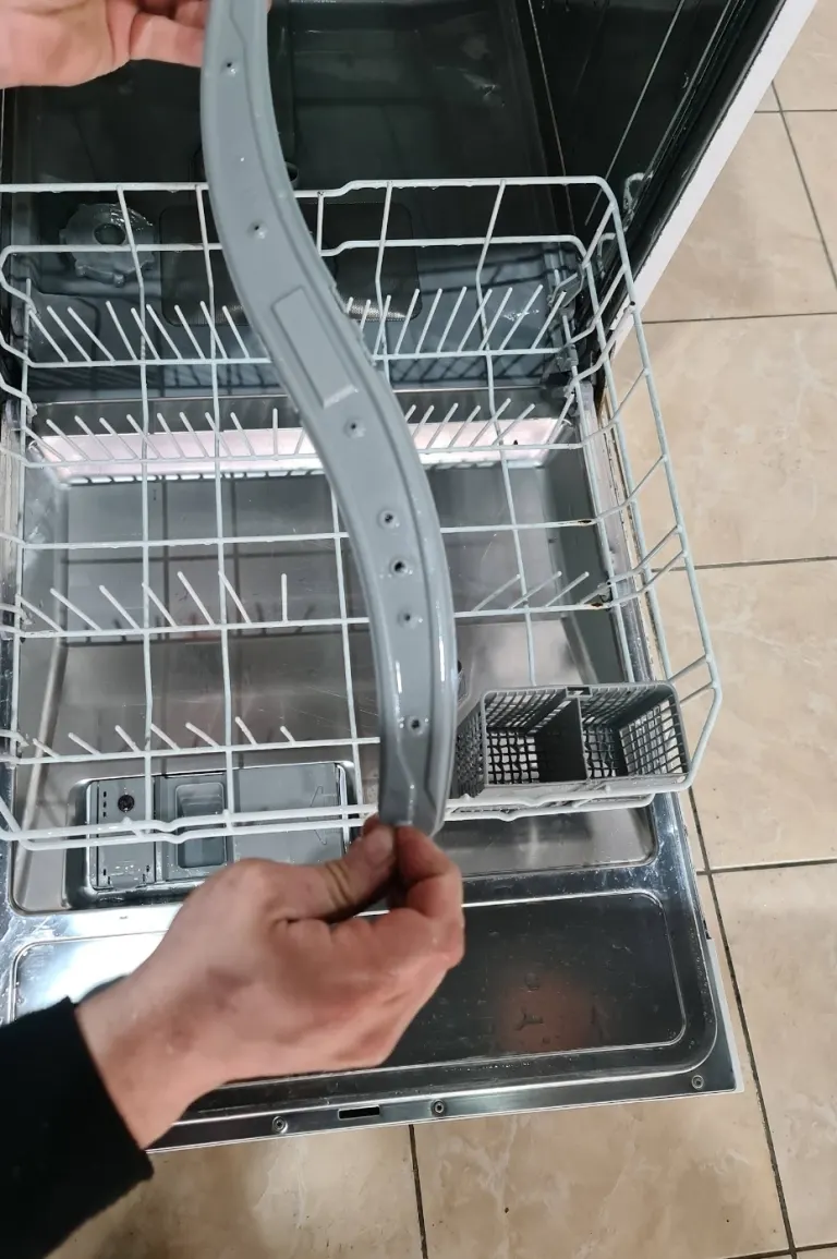 Bulaşık makinesinde püskürtme kolu sökülüp delikleri kontrol ediliyor